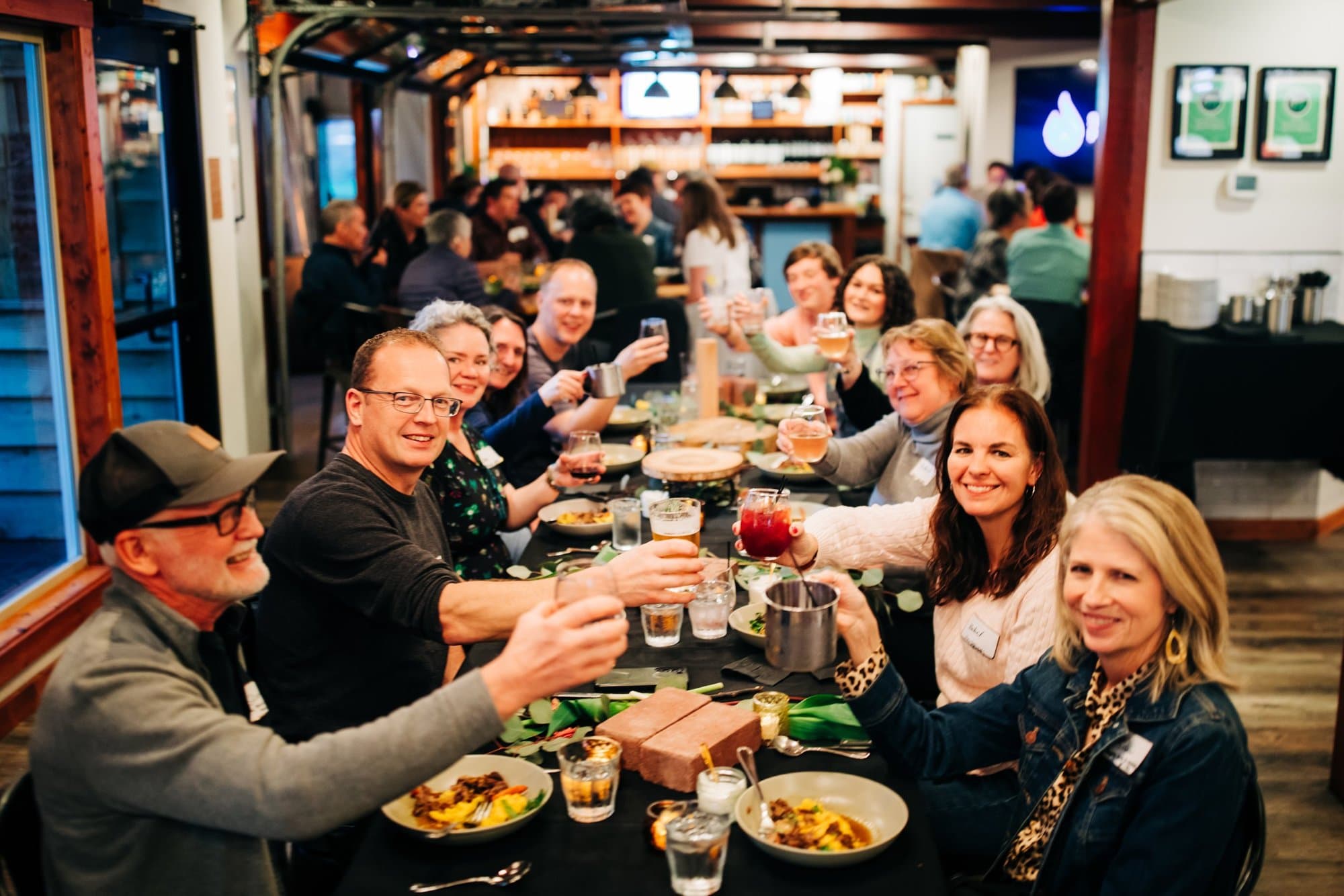 A company group raising glasses at a long table
