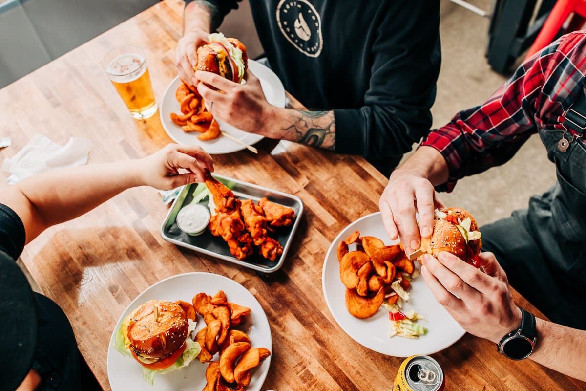 Wings, burgers and fries on a shared table
